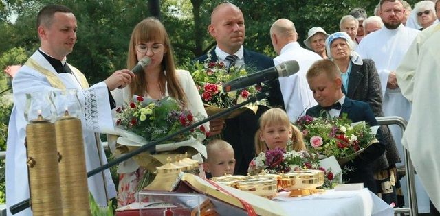 Una familia lleva flores a la Virgen Kebelska en Wawolnica