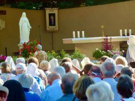 Peregrinos a Pellevoisin asisten a misa ante la imagen de Nuestra Señora de la Misericordia.